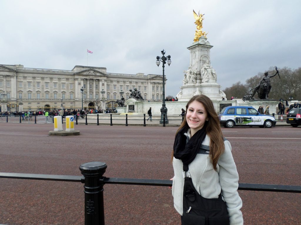 Julia standing in front of Buckingham Palace, which is one of the most popular places to visit in London.